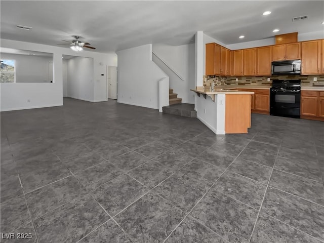 kitchen featuring ceiling fan, black appliances, kitchen peninsula, decorative backsplash, and a breakfast bar area