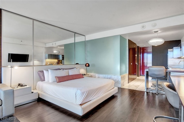 bedroom with a closet, dark hardwood / wood-style flooring, and sink