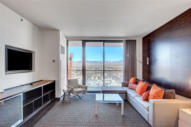 living room with a wall of windows, a mountain view, and hardwood / wood-style floors