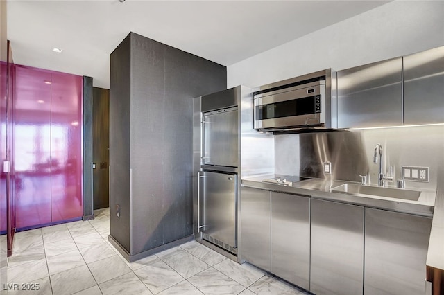 kitchen with stainless steel counters, fridge, sink, and black electric stovetop