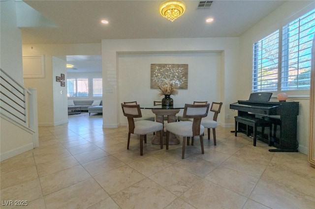 dining space featuring light tile patterned floors and a chandelier