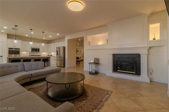 tiled living room with a fireplace and sink