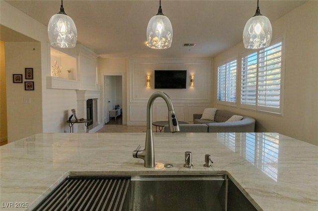 kitchen with sink, hanging light fixtures, and white cabinets