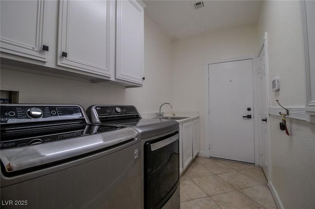 washroom featuring washer and clothes dryer, sink, light tile patterned floors, and cabinets