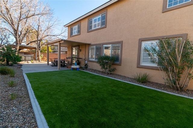 back of house with a yard and a patio