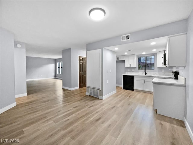 kitchen with white cabinetry, black dishwasher, sink, light wood-type flooring, and stove