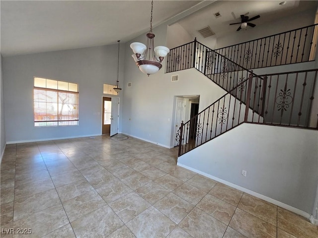 interior space featuring ceiling fan with notable chandelier and high vaulted ceiling