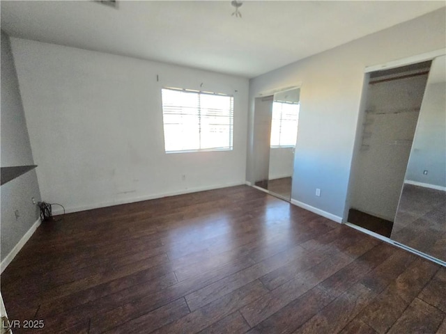 unfurnished bedroom with dark wood-type flooring and a closet