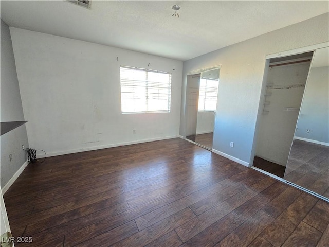 unfurnished bedroom featuring a closet and dark hardwood / wood-style floors