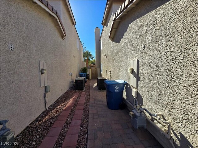 view of side of home featuring central AC unit and a patio