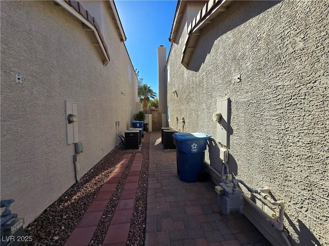 view of side of home featuring cooling unit and a patio