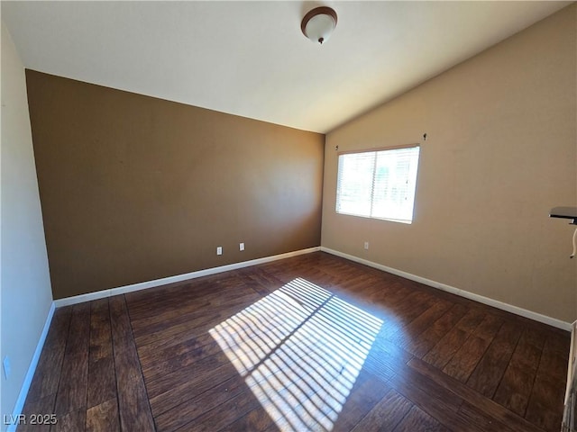 spare room featuring dark hardwood / wood-style flooring and vaulted ceiling