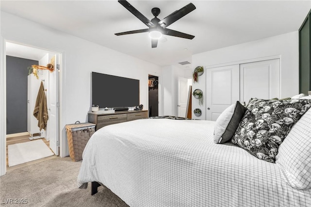 bedroom featuring ceiling fan, light carpet, a closet, and connected bathroom