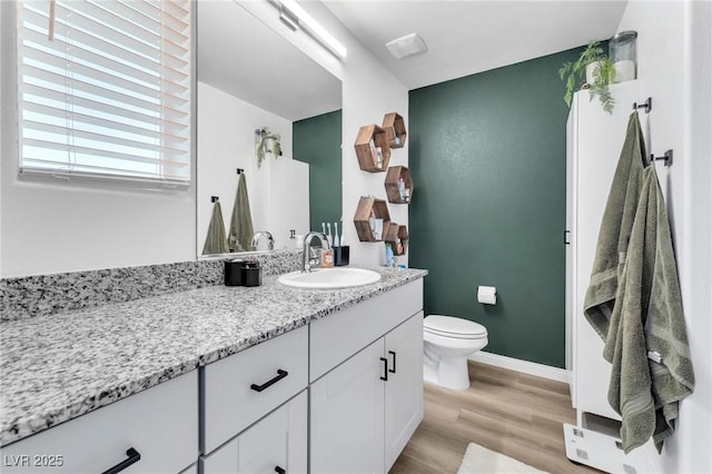 bathroom with wood-type flooring, toilet, and vanity