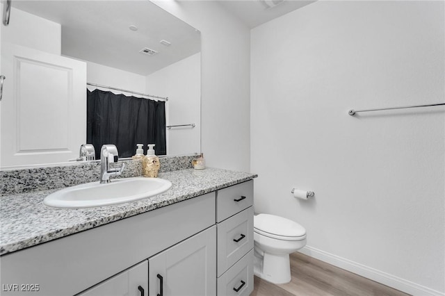 bathroom with hardwood / wood-style flooring, toilet, vanity, and a shower with curtain