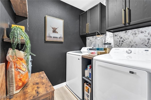 laundry area with cabinets, separate washer and dryer, and light hardwood / wood-style flooring