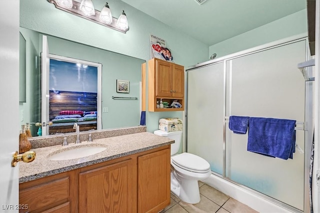 bathroom featuring toilet, tile patterned flooring, a shower with shower door, and vanity