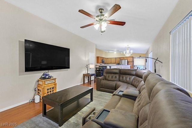 living room featuring light hardwood / wood-style floors and ceiling fan with notable chandelier