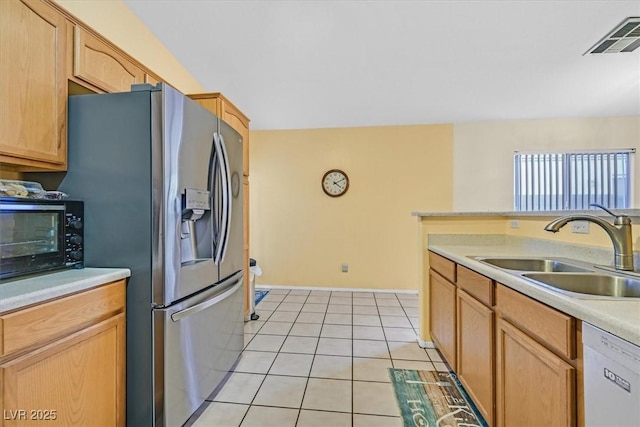 kitchen featuring stainless steel fridge with ice dispenser, light tile patterned floors, light brown cabinets, white dishwasher, and sink