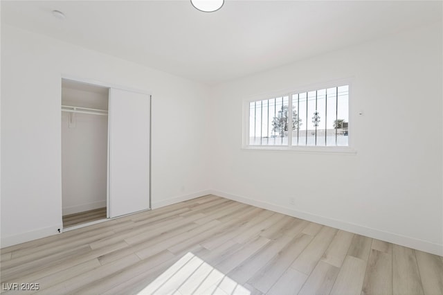 unfurnished bedroom with a closet and light hardwood / wood-style flooring