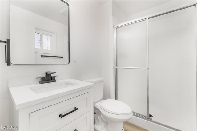 bathroom featuring toilet, vanity, and walk in shower