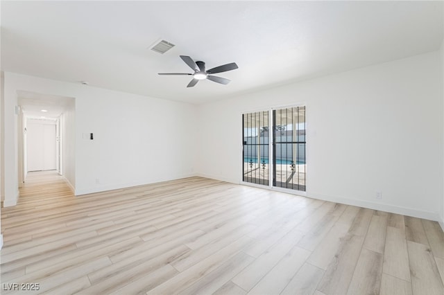 empty room with ceiling fan and light hardwood / wood-style flooring