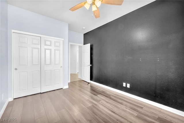 5640 Akula Bay St, North Las Vegas, NV 89081 - unfurnished bedroom featuring wood finished floors, baseboards, a closet, and a ceiling fan