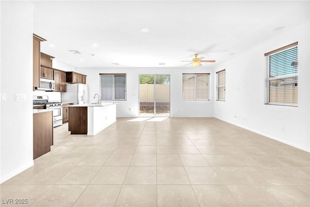 5640 Akula Bay St, North Las Vegas, NV 89081 - kitchen featuring appliances with stainless steel finishes, open floor plan, a ceiling fan, light countertops, and a kitchen island with sink