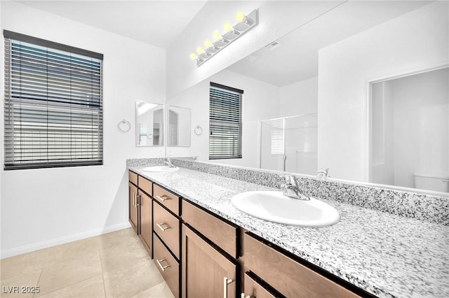 5640 Akula Bay St, North Las Vegas, NV 89081 - full bathroom with double vanity, a stall shower, baseboards, tile patterned floors, and toilet