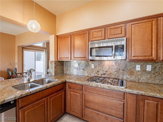 kitchen with decorative backsplash, sink, stainless steel appliances, and pendant lighting