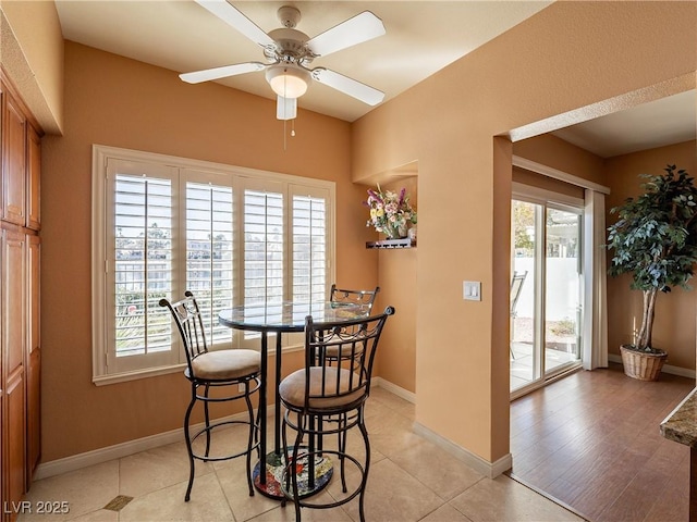 tiled dining area featuring ceiling fan and a wealth of natural light