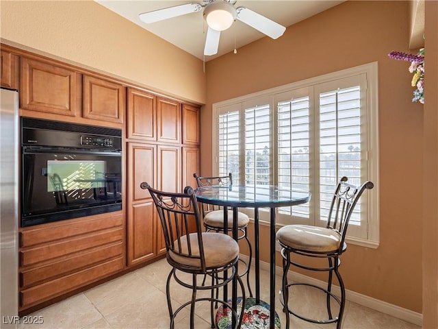 tiled dining space with ceiling fan