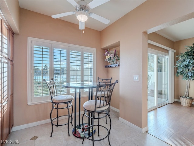 tiled dining area with ceiling fan and a healthy amount of sunlight