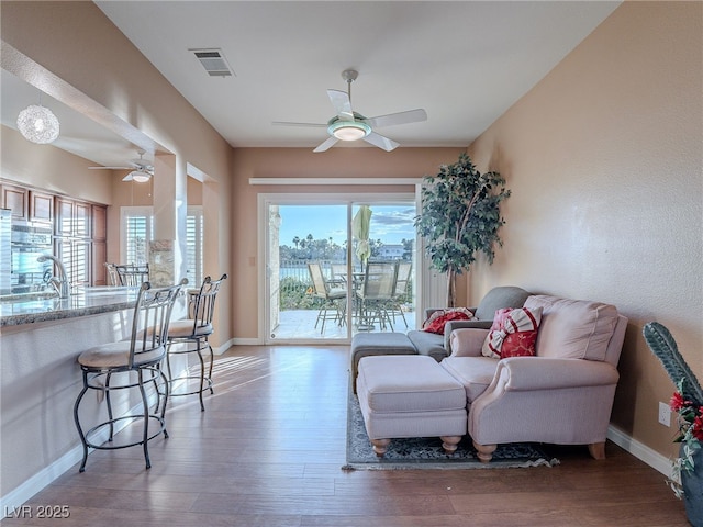 sitting room with ceiling fan, sink, and hardwood / wood-style floors