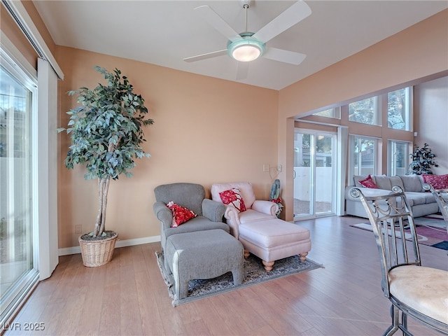 sitting room with ceiling fan, a healthy amount of sunlight, and hardwood / wood-style floors