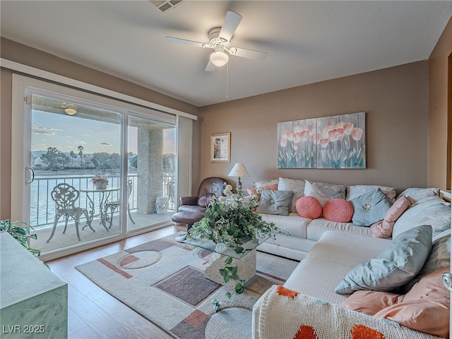 living room featuring light wood-type flooring and ceiling fan