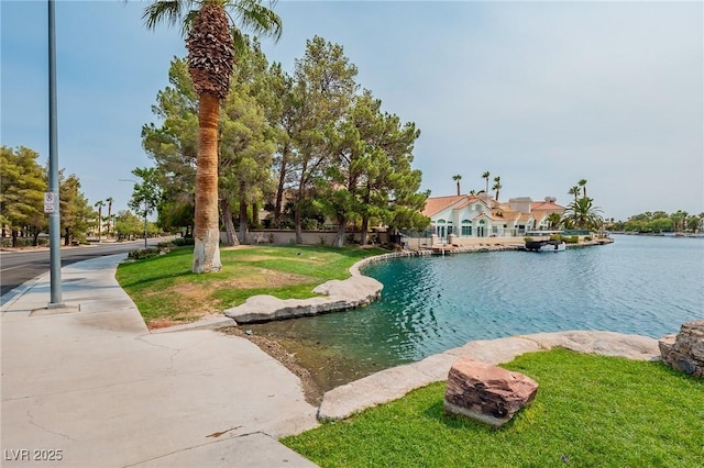 view of swimming pool featuring a lawn and a water view