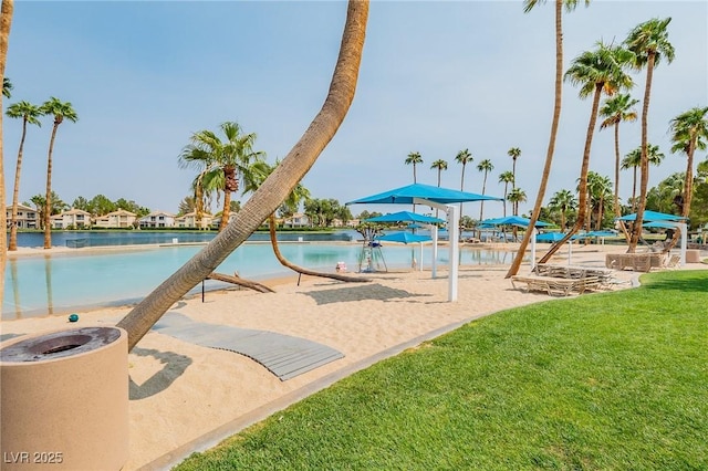 view of pool with a water view and a lawn