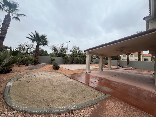 view of yard with ceiling fan and a patio area