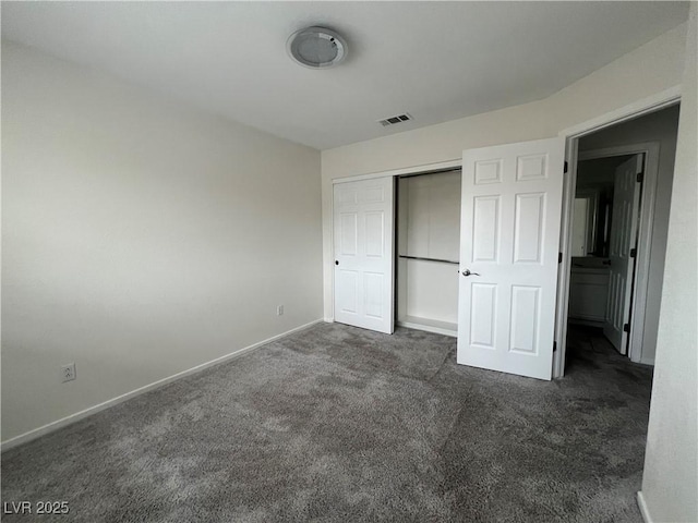 unfurnished bedroom with dark carpet and a closet