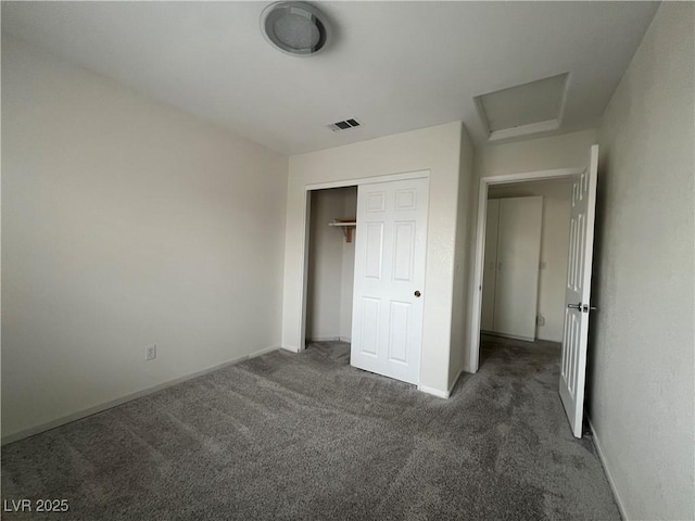 unfurnished bedroom with a closet and dark colored carpet