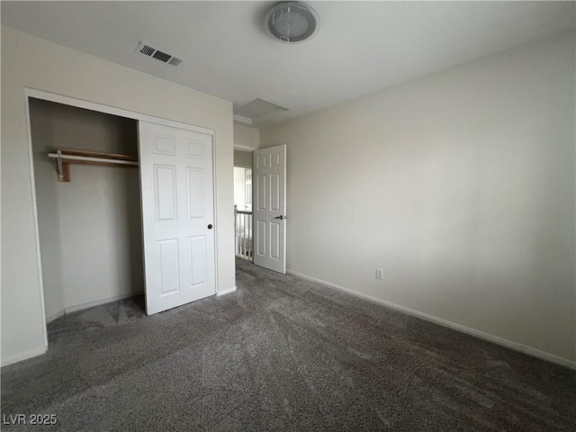 unfurnished bedroom featuring a closet and dark carpet