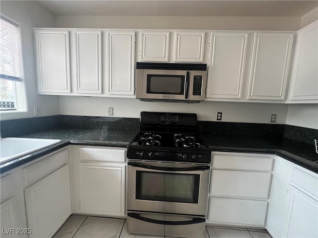 kitchen featuring white cabinets, light tile patterned floors, and stainless steel appliances