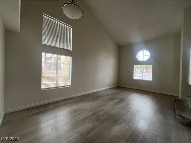 interior space with high vaulted ceiling, plenty of natural light, and hardwood / wood-style floors