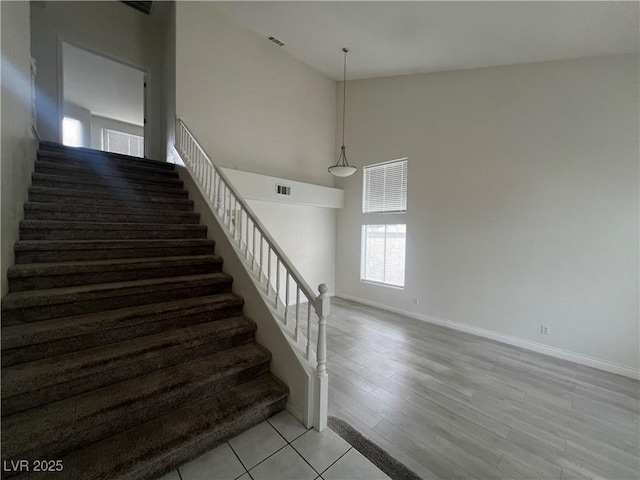 stairway with a high ceiling and hardwood / wood-style floors