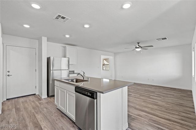 kitchen with a center island with sink, stainless steel appliances, white cabinetry, and sink