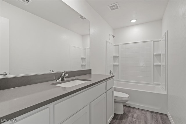 full bathroom with hardwood / wood-style flooring, washtub / shower combination, toilet, and vanity