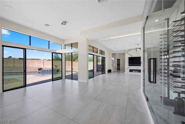 unfurnished living room with ceiling fan and a fireplace