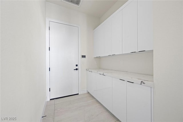 clothes washing area featuring light tile patterned flooring