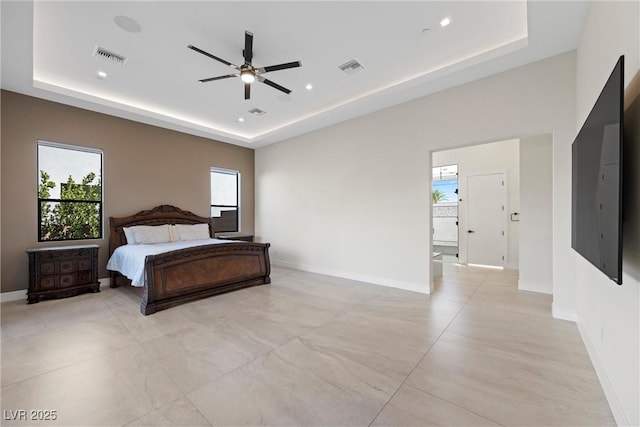 bedroom with ceiling fan and a tray ceiling